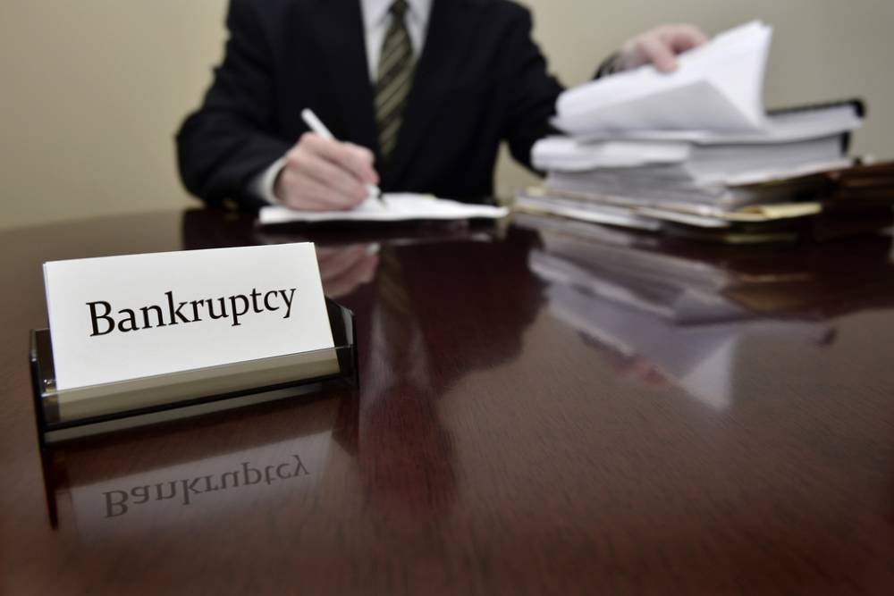 Five Signs It’s Time to Consider Filing for Bankruptcy - Bankruptcy attorney or accountant sitting at desk with files and papers
